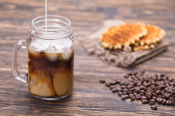 Ice coffee and coffee beans on the background.