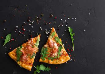 Pizza with prosciutto and rocket salad copy space