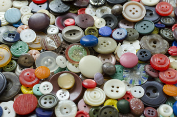 Colored plastic buttons on brown wooden background