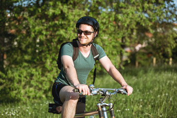 Obraz premium Young man sitting on his bike in nature