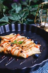 sweet crepe filled with almond and blueberry set on dinner table.