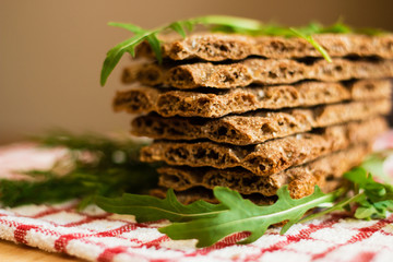 Crispbread with ruccola on tablecloth in red cage