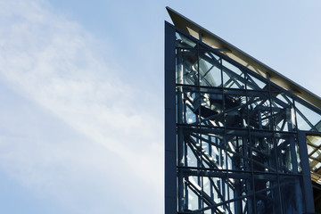 The glass elevator shaft with metal partitions on the street adjoins the bridge.