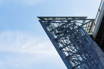 The glass elevator shaft with metal partitions on the street adjoins the bridge.