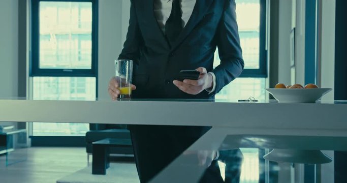 Businessman drinking juice and using smartphone