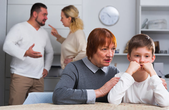 Grandmother comforting grandson while parents quarreling