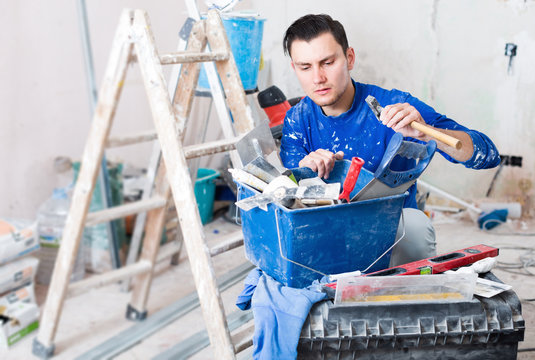 Handyman choosing necessary tool in toolbox