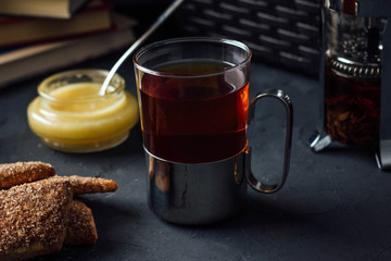Glass cup of tea with biscuits and honey
