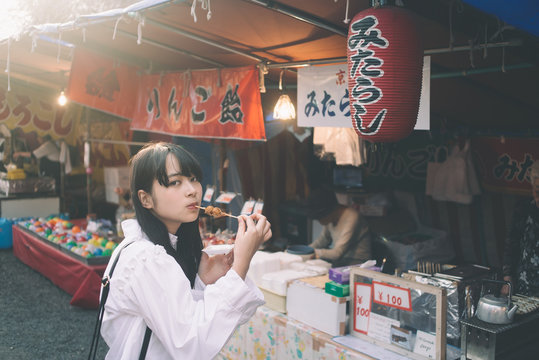 祭りで団子を食べる女性