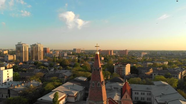 Aerial view of summer Odessa: Lutheran Cathedral of St. Paul, green streets, rooftops, Black Sea and port in the evening sunlight. Architectural monument German Evangelical Lutheran Church of Ukraine.