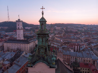 Obraz premium old church tower with sunrise on background. european cityscape aerial view