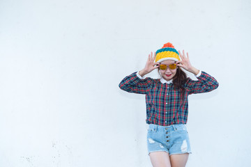 Asian hipsters girl posing for take a photo on white wall,lifestyle of modern woman wear short denim,Thai people in hippie style,sweet lady act for photo shoot outdoor