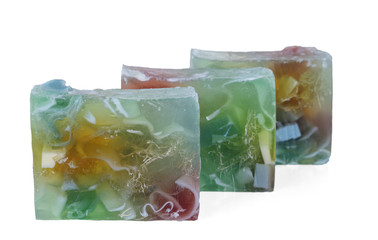 Three multi-colored pieces of handmade soap isolated on white background. Selective focus.