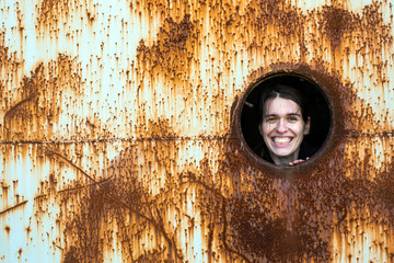 Young woman joyfully looks out of the window of an abandoned bunker.