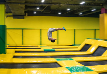 trampoline jumper performs complex acrobatic exercises and somersault on the trampoline.