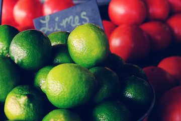 Fototapeta na wymiar Fresh bright green limes in a group at public market.