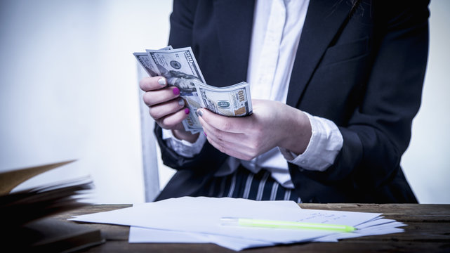 Beautiful success business woman holding 100 dollar currency banknotes. (Money, wealth, work, salary concept)