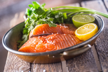 Raw salmon fillets with parsley herbs lime lemon salt and dried saffron