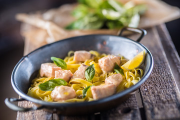 Pieces of salmon with pasta tagliatelle lemon and basil