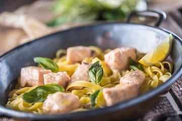 Pieces of salmon with pasta tagliatelle lemon and basil