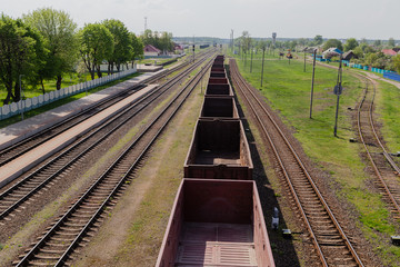Obraz premium Railroad in motion at sunset. Railway station with motion blur effect against colorful blue sky, Industrial concept background. Railroad travel, railway tourism. Blurred railway. Transportation