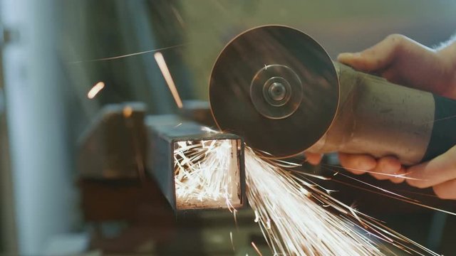 worker cutting metal with a power tool