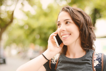 Portrait of a young beautiful woman talking with her smartphone