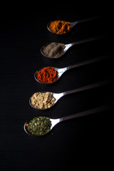 Spices colored in silver spoons
