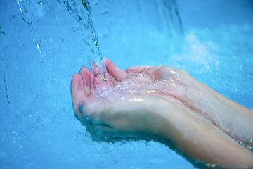 Cool water stream and hands. Fresh water current. Woman hands in water flow. Hygiene concept photo.