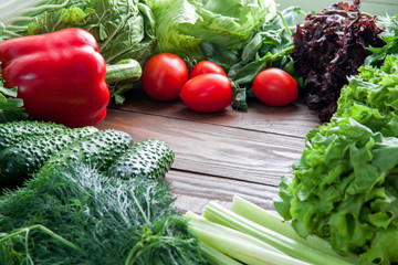 dietary and healthy assortment for cooking food from greens and red vegetables on a wooden table