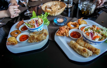 delicious mixed dish of fried spring roll, prawn fritters, deep fried squid cuttlefish and fried wonton, asian cooking and recipe
