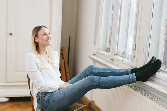 Smiling young woman sitting daydreaming