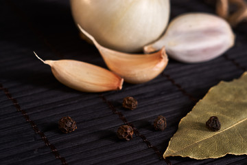 Fototapeta na wymiar onion, garlic, black pepper and bay leaf on a black background