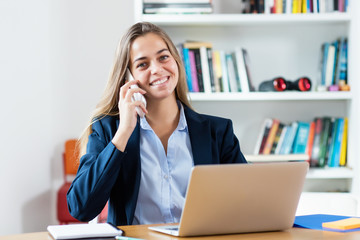 Blonde businesswoman speaking with customer at phone