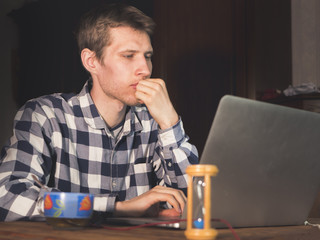 young man programmer sitting at the table in front of laptop