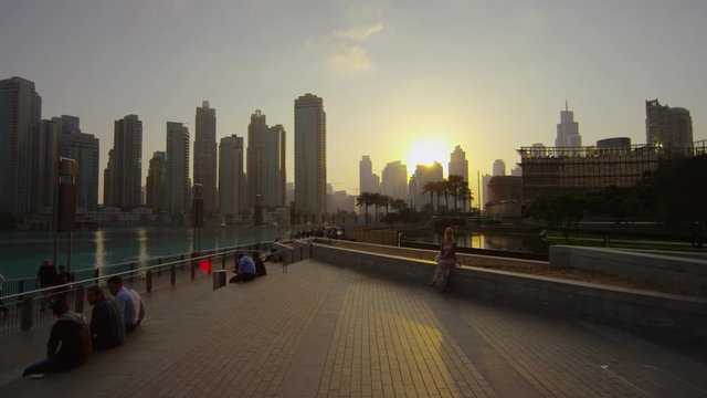 People relaxing at sunset in Burj Khalifa Bay, Dubai