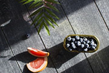 the palm branches in focus against the background of slices of grapefruit and a blueberry