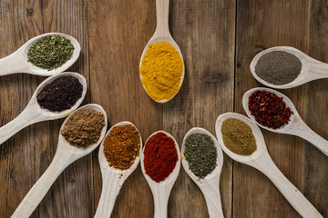 Assorted spices on wooden spoons. Delicious food ingredients.