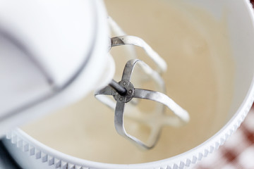 Electric mixer being used to mix ingredients for a cake. Making of a cream for home-made cakes on a mixer