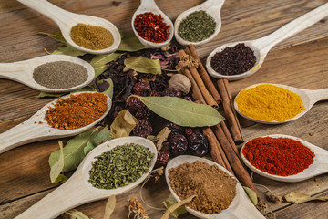 Assorted spices on wooden spoons. Delicious food ingredients.