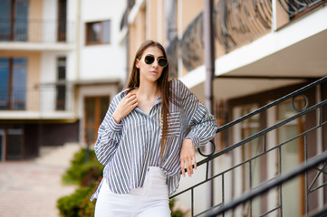 Fototapeta premium Portrait of pensive fair-haired dreamy hipster girl imagines something in her mind, looks upwards, being deep in thoughts, touching hair. Attractive young blonde female dreams about weekends