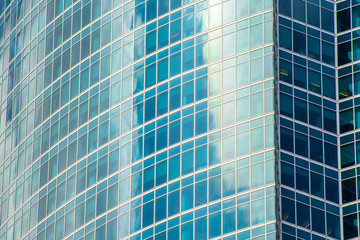 Reflection shiny green, emerald color glass, wave with bend facade windows of financial skyscrapers.