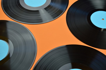 old black vinyl records with blank cyan labels on orange background