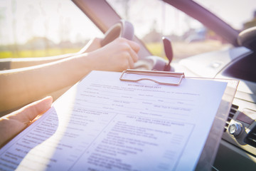 Examiner filling in driver's license road test form