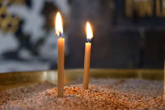 Two candles burn in the Orthodox Church before the icons