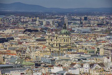 Fototapeta na wymiar View on the basilica of Saint Istvan in Budapest, Hungary, panoramic view and blooming trees from viewpoint on Gellert hill on sunny spring day