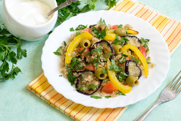 Quinoa with fried eggplants and peppers, tomatoes, olives, parsley