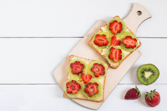 Toast with cream cheese, kiwi and strawberries in form of flowers