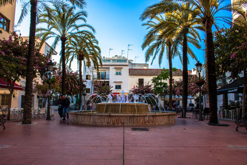 Fototapeta na wymiar Square. A small square with restaurants and a fountain in Estepona. Malaga province, Andalusia, Spain. Picture taken – 4 may 2018.