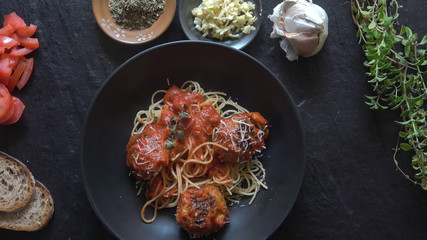 Spaghetti and Italian Meatballs on a dark slate background.